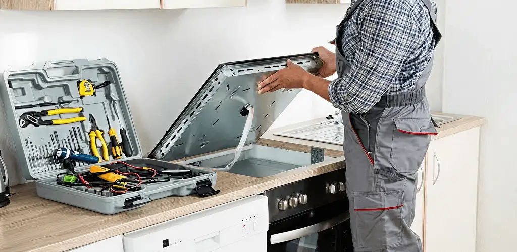 Handyman repairing a cooktop and checking wiring connections in Indianapolis, IN