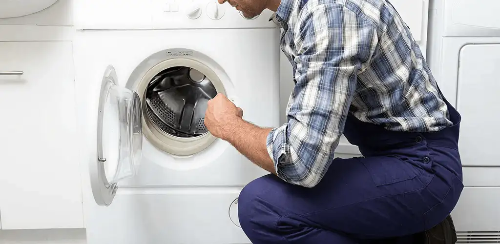 Handyman inspecting a dryer drum and internal parts for repair in Indianapolis, IN