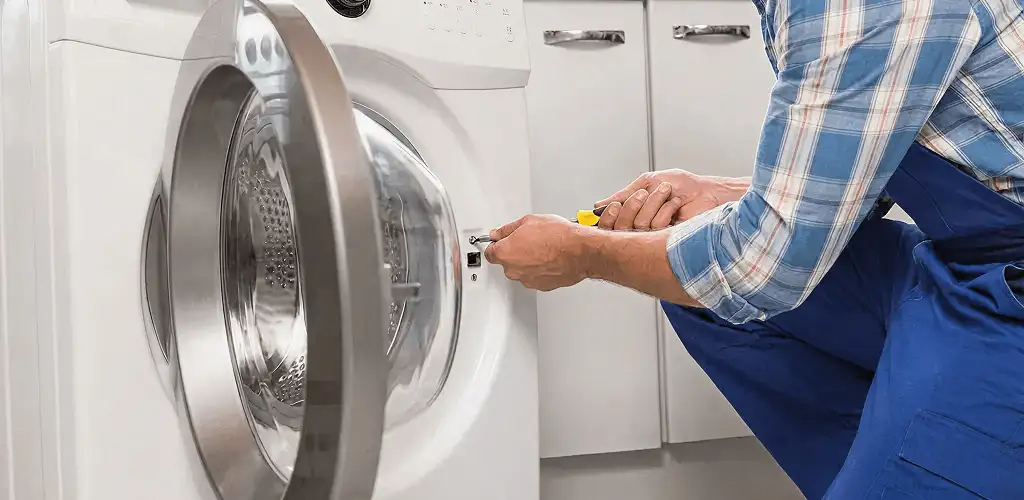Handyman repairing a clothes dryer and checking electrical connections in Indianapolis, IN