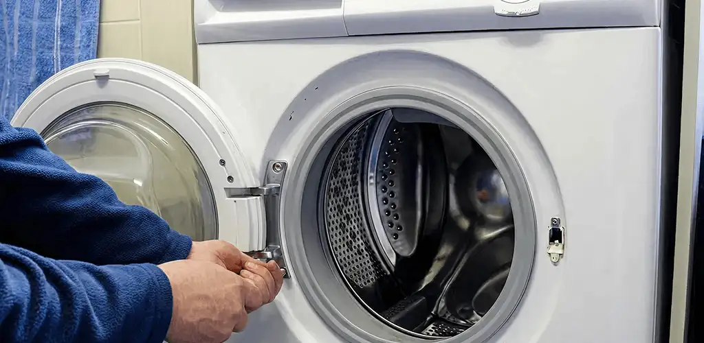 Washing machine repair handyman checking a front-load washer door and latch in Indianapolis, IN