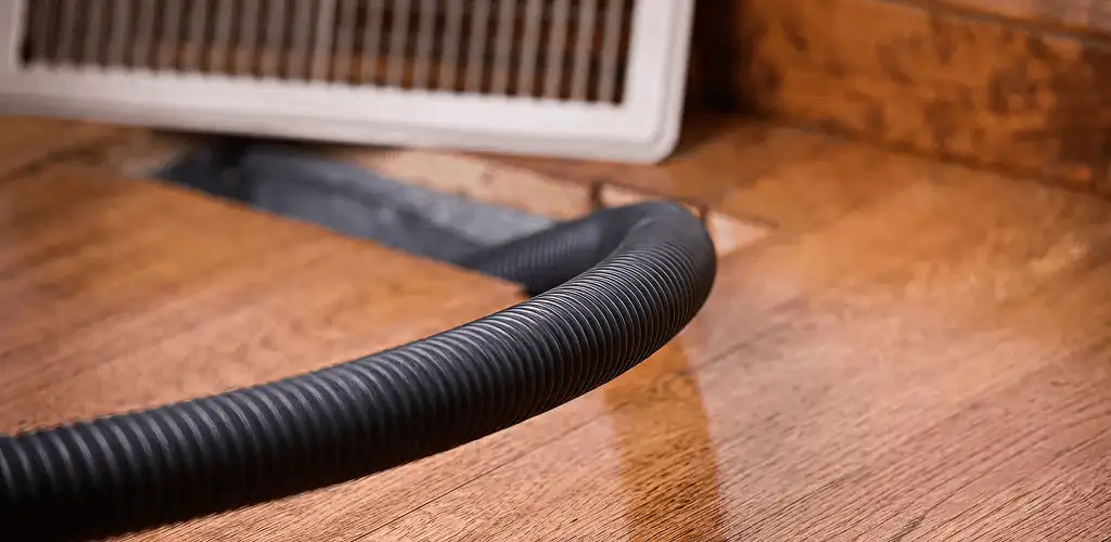 Air duct cleaning hose inserted into a floor vent for ductwork cleaning in Indianapolis, IN