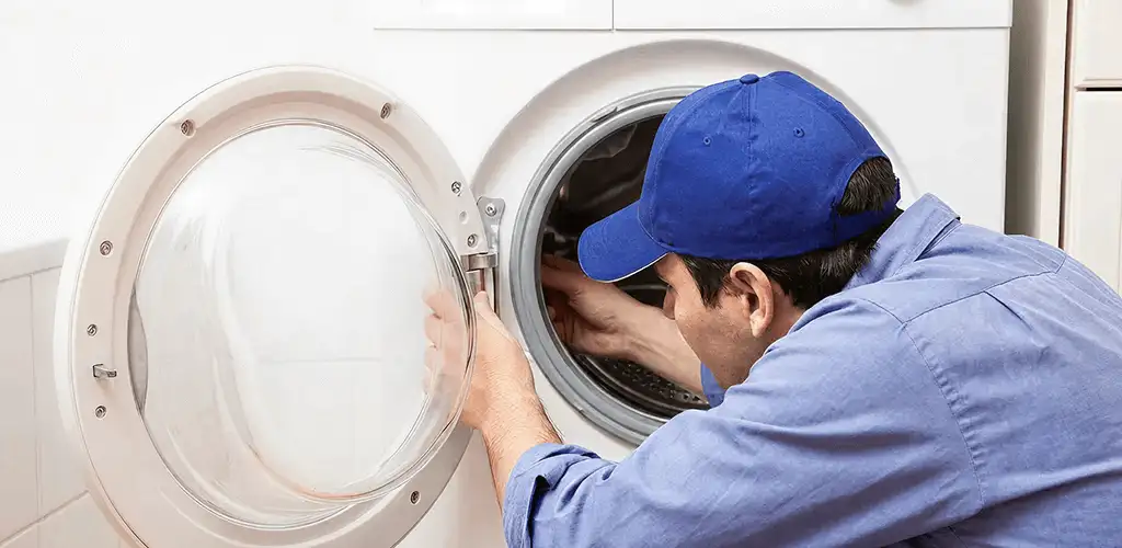 Washing machine repair handyman inspecting a front-load washer drum in Indianapolis, IN